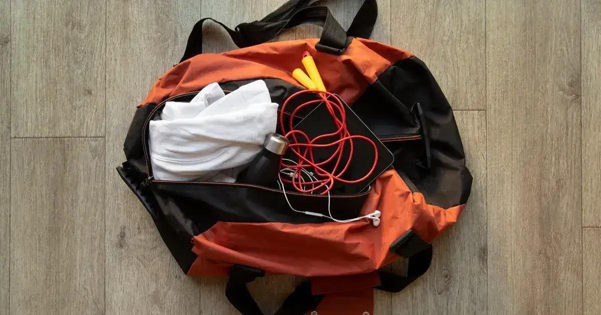 Hiking and survival equipment organized on wooden surface for building an evacuation bag