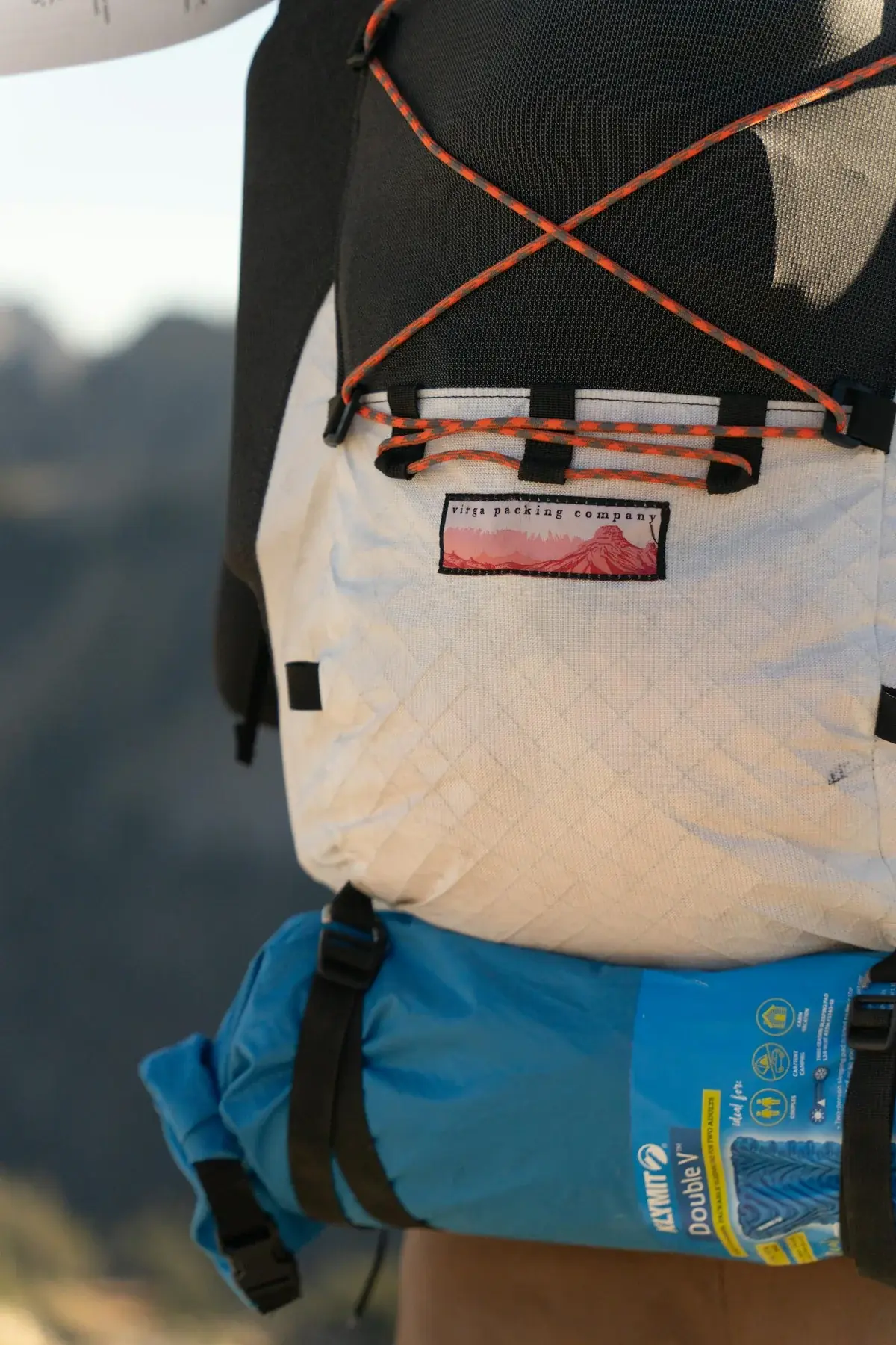 Survival backpack with gear laid out: flashlight, multitool, water, food, first aid kit