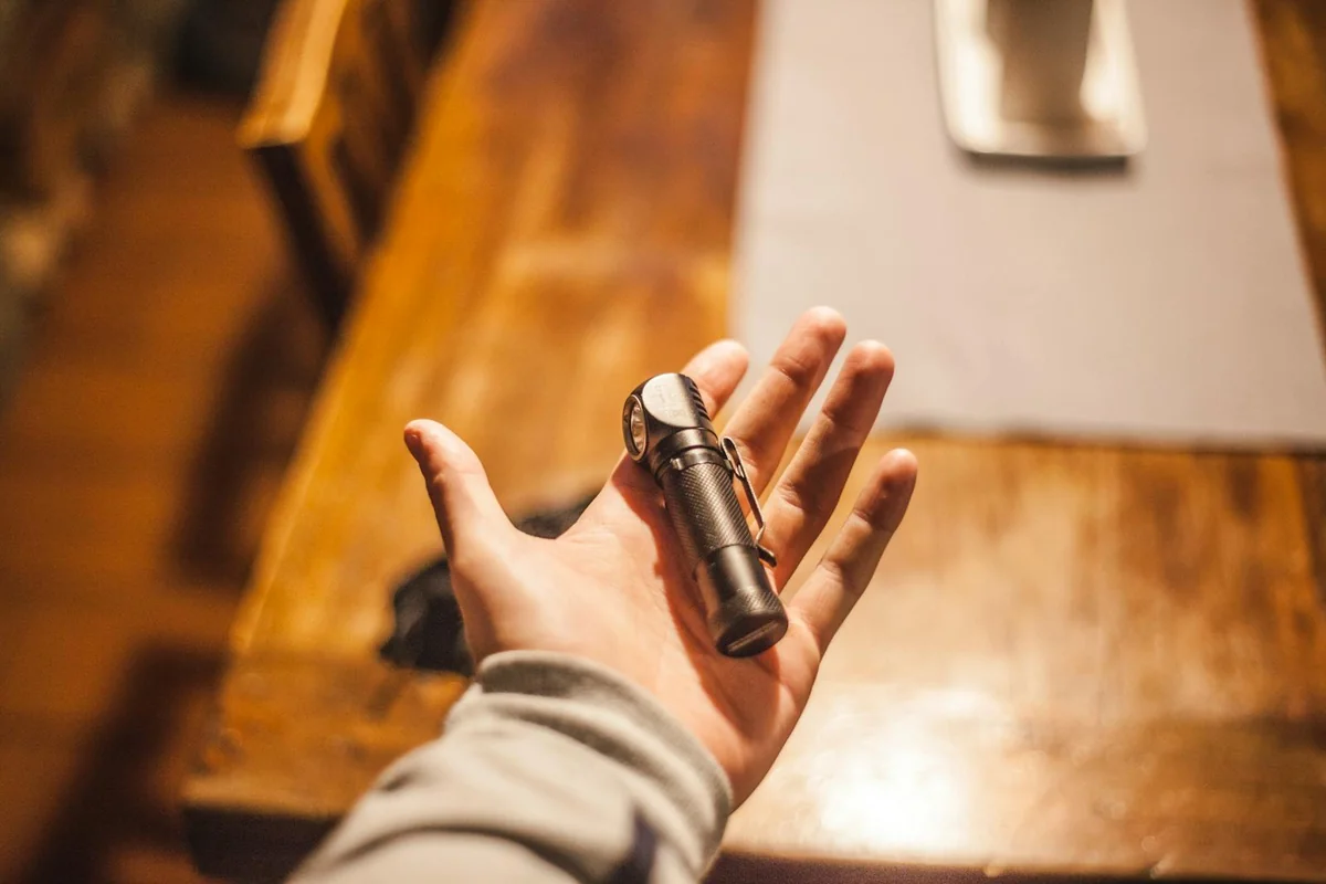 Hand holding an LED flashlight lighting a hallway during a power outage — 72-hour emergency kit in real use